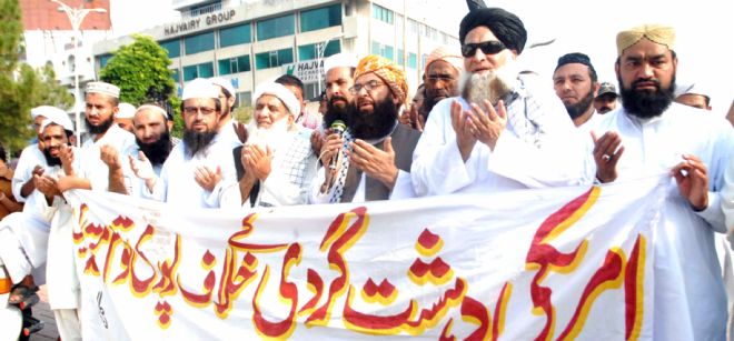 Seguidores del partido político Jamiat Ulma-e-Islam sostienen una pancarta en la que se puede leer 