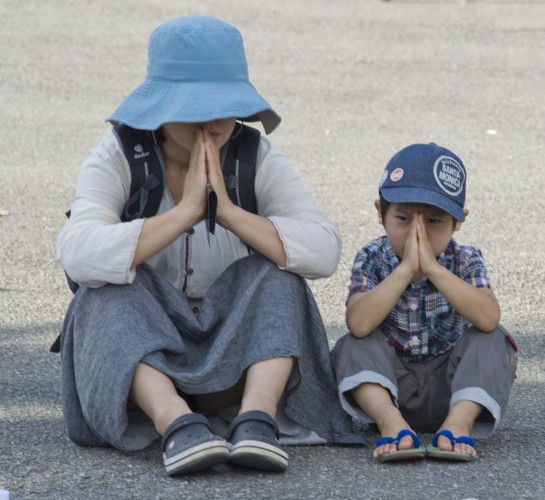 Una madre reza junto a su hijo por las víctimas del terremoto.