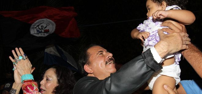 El Presidente de Nicaragua Daniel Ortega (c), y la primera dama Rosario Murillo (i) saludan a sus seguidores.