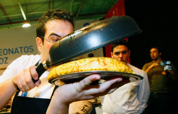 Uno de los participantes en el concurso nacional de tortilla de patatas da la vuelta a su tortilla.