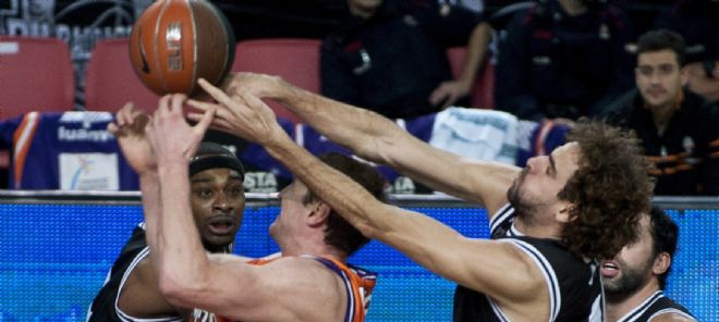 El pívot ucraniano del Valencia Basket Serhiy Lishchuk (2i) disputa un rebote con los jugadores del Gescrap Bizkaia D'Or.