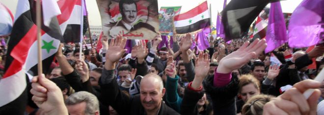 Sirios gritan consignas en favor del régimen de Bachar Al Asad.