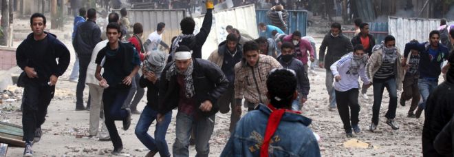 Manifestantes egipcios corren para huir del gas lacrimógeno.