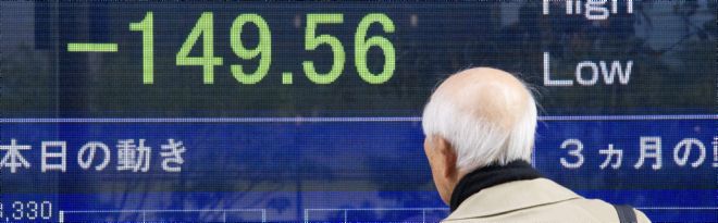 Un hombre se detiene ante una pantalla con el valor del índice Nikkei.