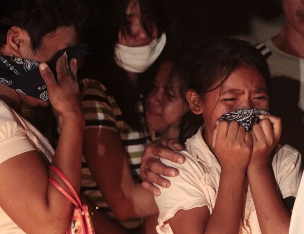 Los familiares lloran durante un funeral múltiple para las víctimas de las inundaciones en Iligan.