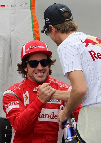 El piloto alemán Sebastian Vettel (d), de la escudería Red Bull, saluda al español Fernando Alonso.
