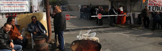 Trabajadores de la empresa siderúrgica Halyvourgia Ellados S.A. montan guardia ante la entrada de la factoría, en Aspropyrgos, cerca de Atenas.