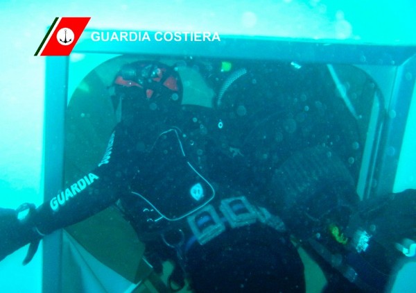 Fotografía cedida por los guardacostas italianos en la que se ve a buceadores de rescate trabajando en el interior del crucero.