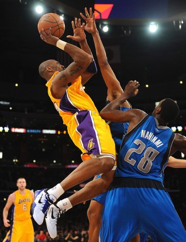 El jugador de los Lakers de Los Angeles Kobe Bryant (c) tira a canasta en presencia de Ian Mahinmi.