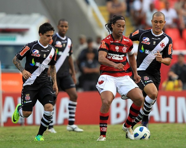 Los jugadores de Vasco Fagner (i) y Nilton (d) disputan el balón con Ronaldinho Gaucho.