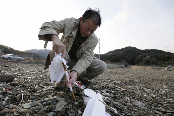Un superviviente del tsunami anclando un piquete en la tierra, en Ishinomaki.