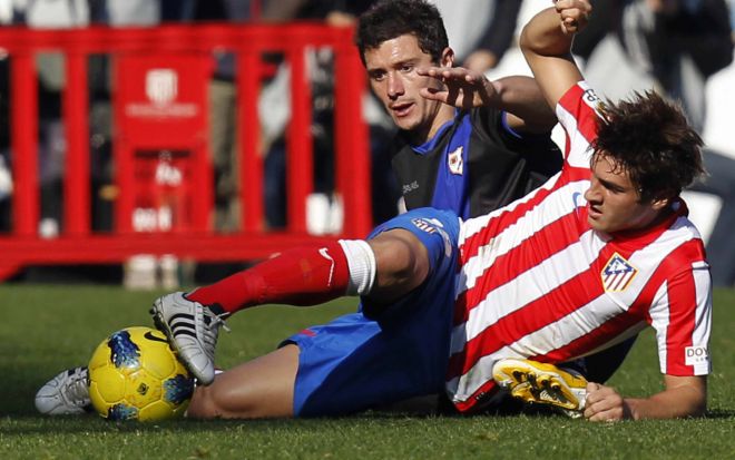 El centrocampista del Atlético de Madrid Koke Resurrección (d) pelea un balón con el centrocampista del Rayo Vallecano Francisco Medina 