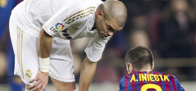 El defensa portugués del Real Madrid, Pepe (i), se interesa por el centrocampista del F. C. Barcelona, Andrés Iniesta, durante el partido de vuelta de los cuartos de final de la Copa del Rey que están disputando esta noche en el Nou Camp, en Barcelona.