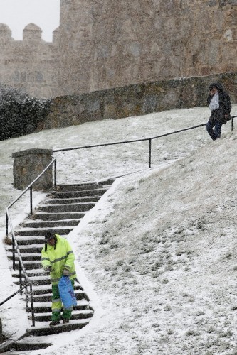 Un operario esparce sal para derretir la nieve caída en las últimas horas en Ávila.