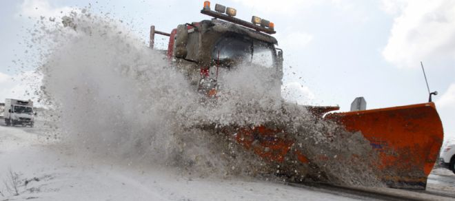 Una máquina quitanieves retira la nieve y el hielo de la carretera CL-505 en la provincia de Ávila.
