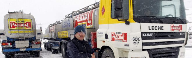 Un camionero junto a dos camiones detenidos en las cercanías de Reinosa (Cantabria).