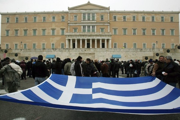 Manifestantes despliegan una bandera griega durante una protesta en contra de las nuevas medidas de austeridad.