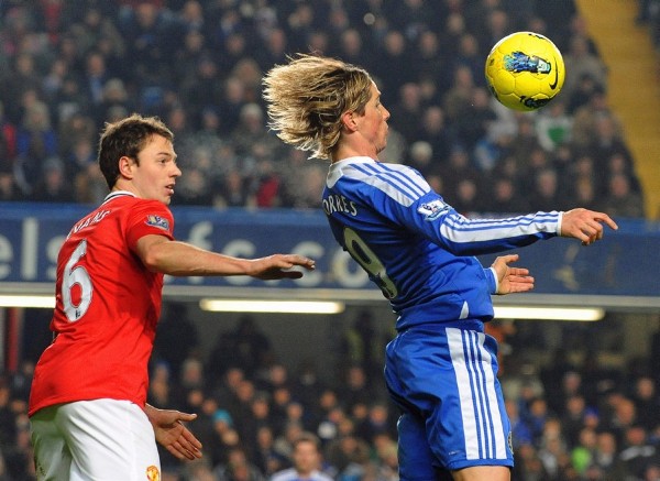 Jonny Evans (izq) del Manchester United lucha por el balón con el delantero español Fernando Torres.