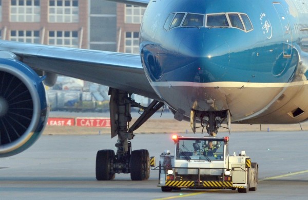 Un vehículo lleva a un avión a su posición de aparcamiento en el aeropuerto alemán.