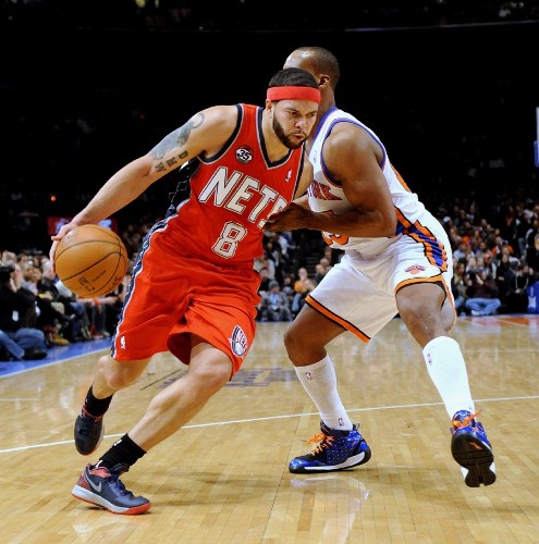 Deron Williams de los New Jersey Nets en acción ante la marca de Baron Davisin de los New York Knicks.