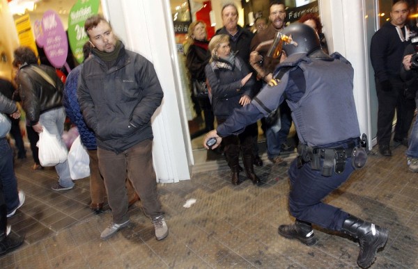 Un policía antidisturbios carga contra un grupo de personas en el entorno del Instituto Lluís Vives, en Valencia.