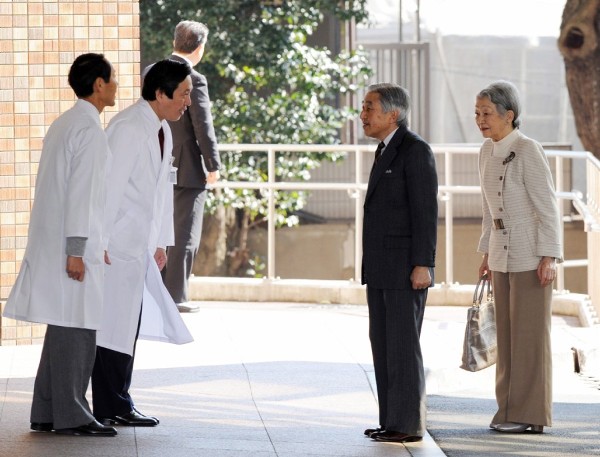 El emperador japonés, Akihito y la emperador, Michiko reciben el saludo de dos doctores.