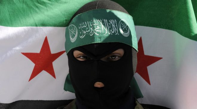 Un joven porta una bandera gigante de la revolución siria.