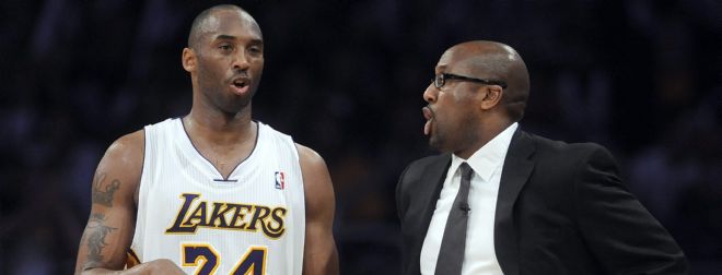 El jugador de los Lakers Kobe Bryant (i) habla con su entrenador, Mike Brown.
