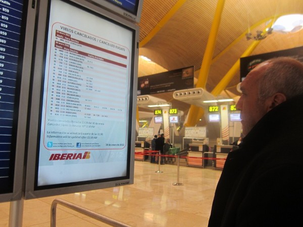 Un viajero mira un panel en Barajas.