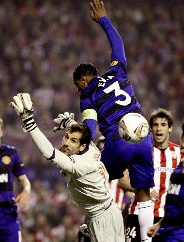 El portero del Athletic Club Gorka Iraizoz (i) intenta despejar un balón ante el defensa francés del Manchester United, Patrice Evra.