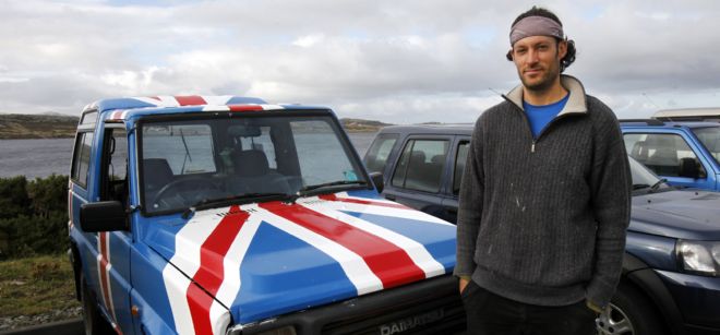 Bill Chater, un residente en las Islas Malvinas, posando frente a su vehículo pintado con la bandera británica.