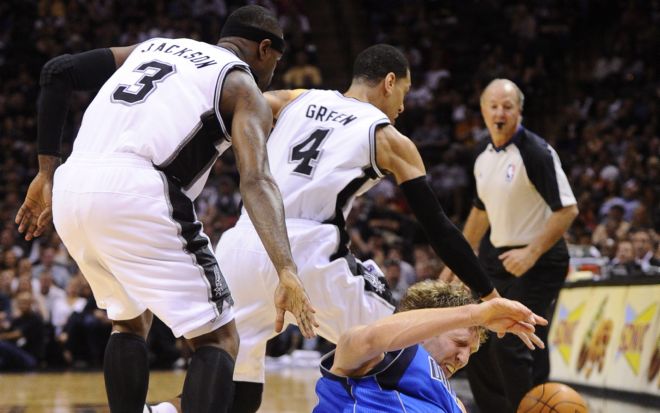 El jugador de los Mavericks Dirk Nowitzki (d) disputa el balón con Stephen Jackson (i) y Danny Green (c) de los Spurs.