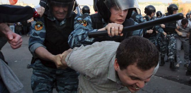 Miembros de las fuerzas antidisturbios detienen a un grupo de opositores.