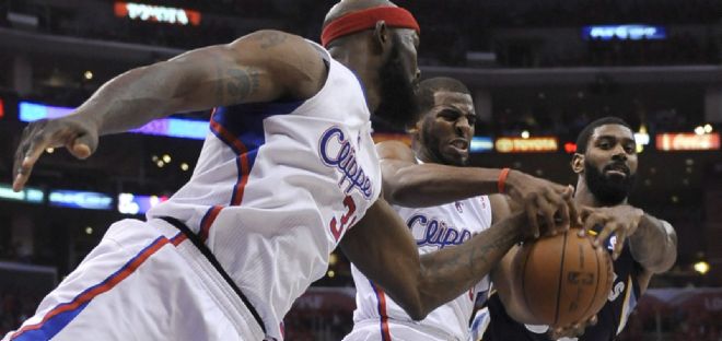 Los jugadores de Clippers Reggie Evans (i) y Chris Paul (c) disputan un rebote con O.J. Mayo.