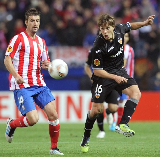 El centrocampista del Valencia, Sergio Canales (d), golpea el balón ante el jugador del At. de Madrid Gabi.