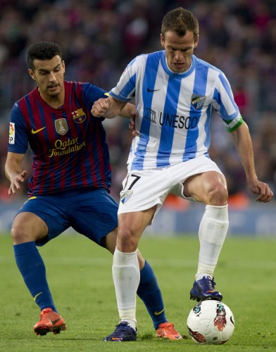El jugador del Barcelona Pedro Rodríguez (i) intenta robar un balón al centrocampista del Málaga Sergio Paulo Barbosa 