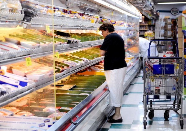 Una mujer selecciona productos en un supermercado.