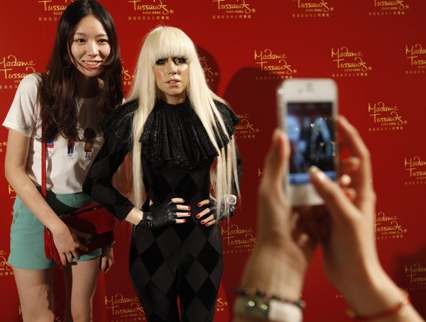 Fans de Lady Gaga se hacen unas fotos junto a una réplica de la cantante en un centro comercial.