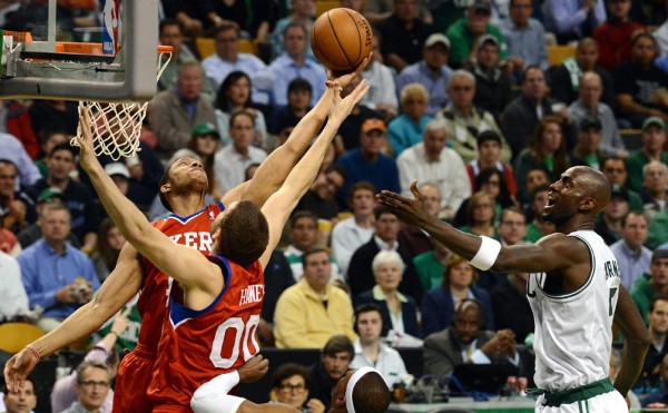 Evan Turner (i) y Spencer Hawes (c) de los Sixers de Filadelfia atrapan un rebote ante Kevin Garnett (d) de los Celtics de Boston.