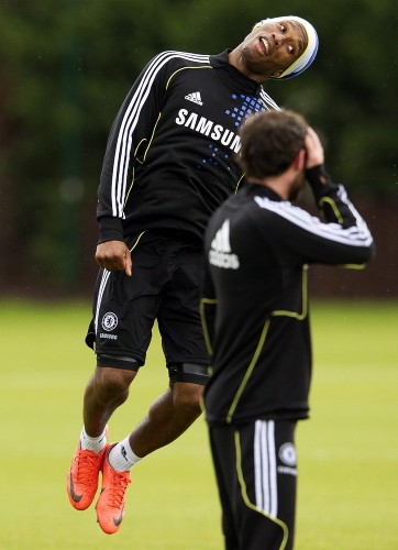 El centrocampista español del Chelsea Juan Mata observa a su compañero Didier Drogba (izda), durante el entrenamiento del equipo.