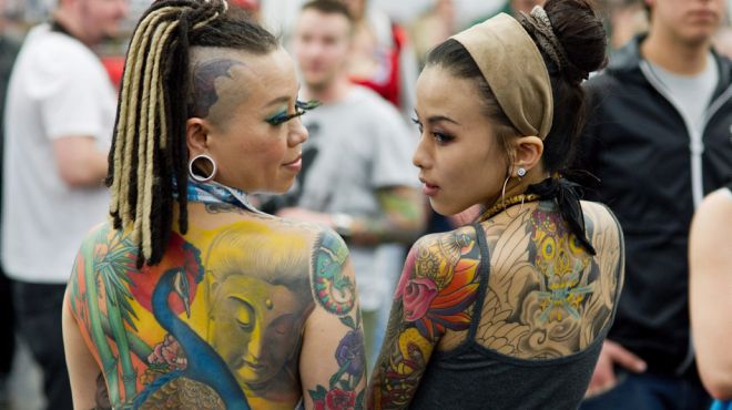 Dos mujeres muestran sus tatuajes.