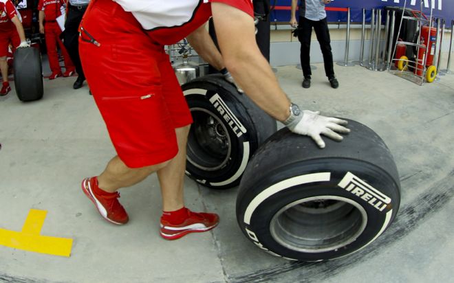Mecánicos de Ferrari preparan neumáticos.