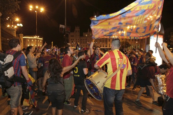 Aficionados del FC Barcelona celebran la victoria del equipo blaugrana en la madrileña plaza de Cibeles.