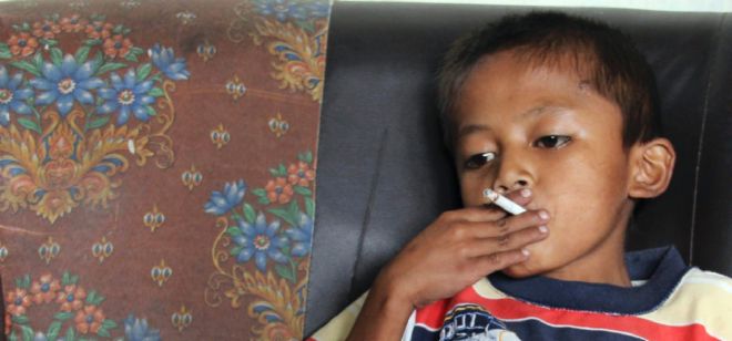 Un niño de 8 años fumando en Indonesia.