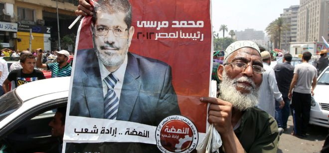 Un simpatizante de los Hermanos Musulmanes sujeta un cartel del candidato Mohamed Mursi.