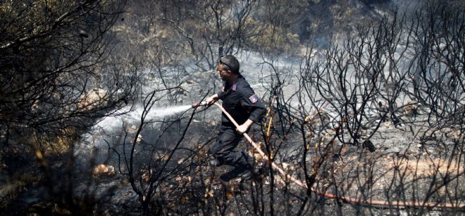 Un bombero intenta sofocar las llamas de un incendio.