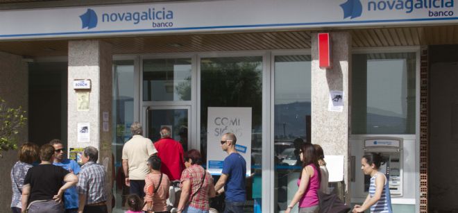Varias personas a las puertas de una de las sucursales bancarias de Novagalicia Banco en Moaña.