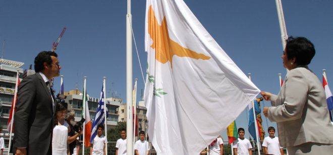 La bandera de Chipre es izada por el ministro de Exteriores de Chipre, Erato Kozakou Marcoullis (d).