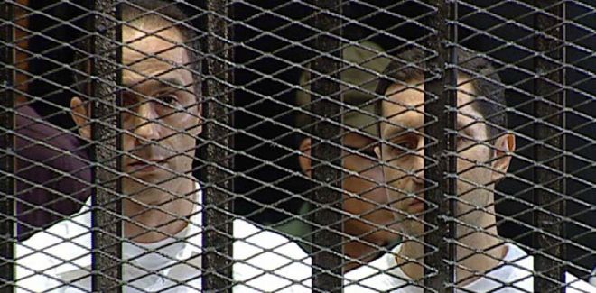 Gamal (izq) y Alaa (der), hijos del expresidente egipcio Hosni Mubarak, tras los barrotes durante el juicio contra ellos.