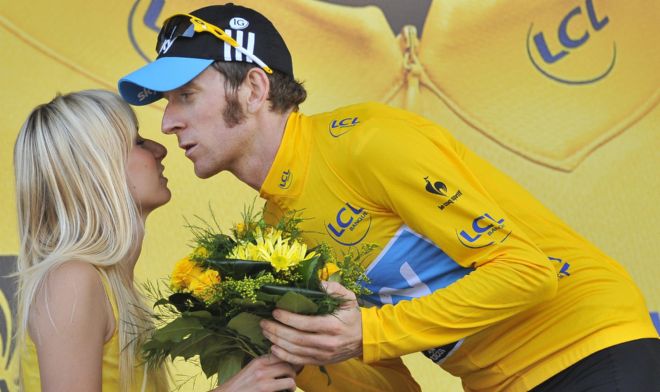 El ciclista británico del equipo Sky, Bradley Wiggins (d), recibe la felicitación de una azafata como líder de la general.